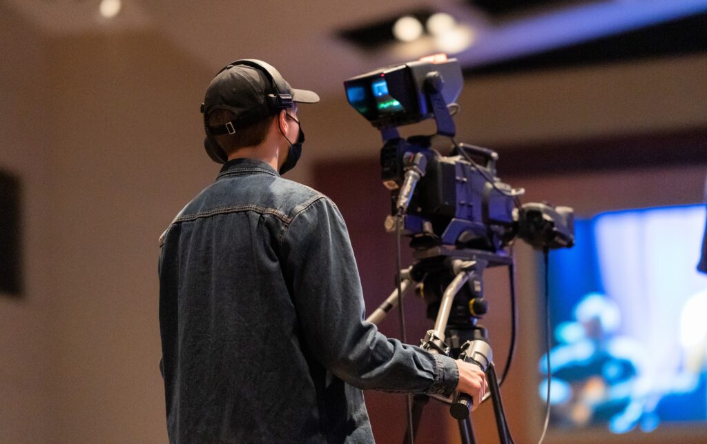 Unrecognizable cameraman recording video of concert on camera