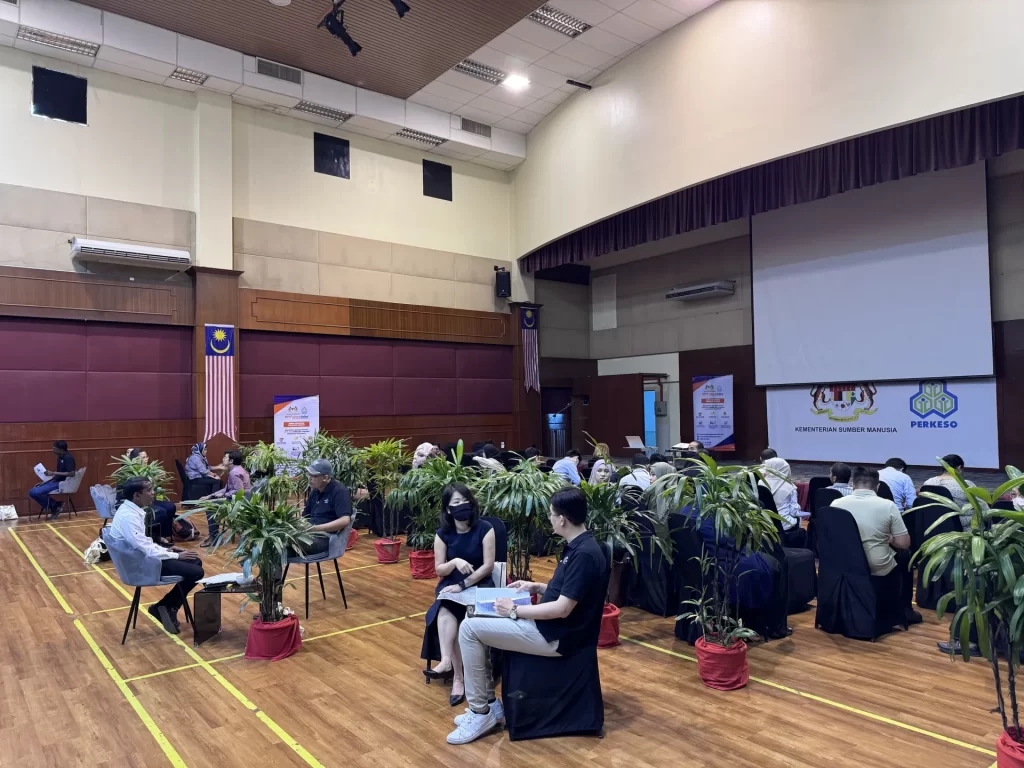 Candidates are sitting on the banquet chairs, waiting for their interview at the MyFutureJobs interview sessions. There are also potted plants, sofa chairs and coffee tables in view.